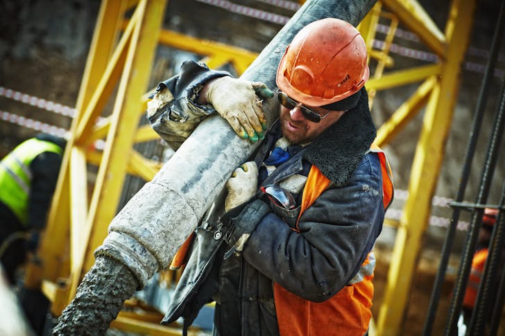 Construction loan rates - Construction worker handles a concrete hose.